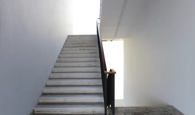 Concrete fire stairwell lit from a landing window