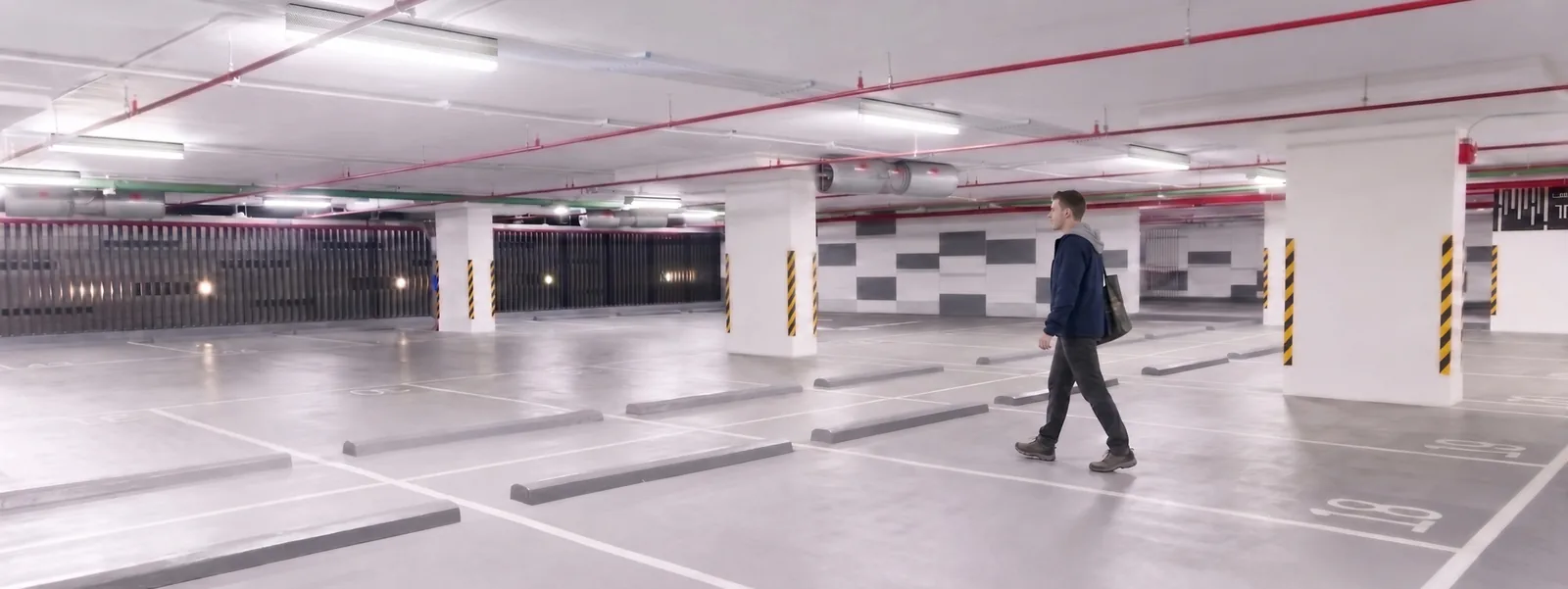 The same car park at full brightness as someone walks through