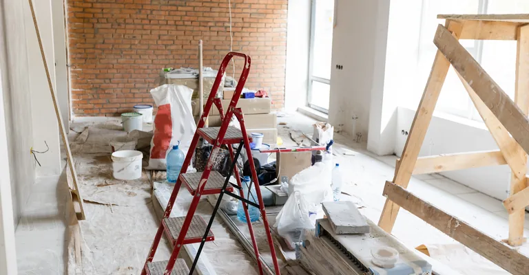 Room stripped back mid-renovation with ladder and materials