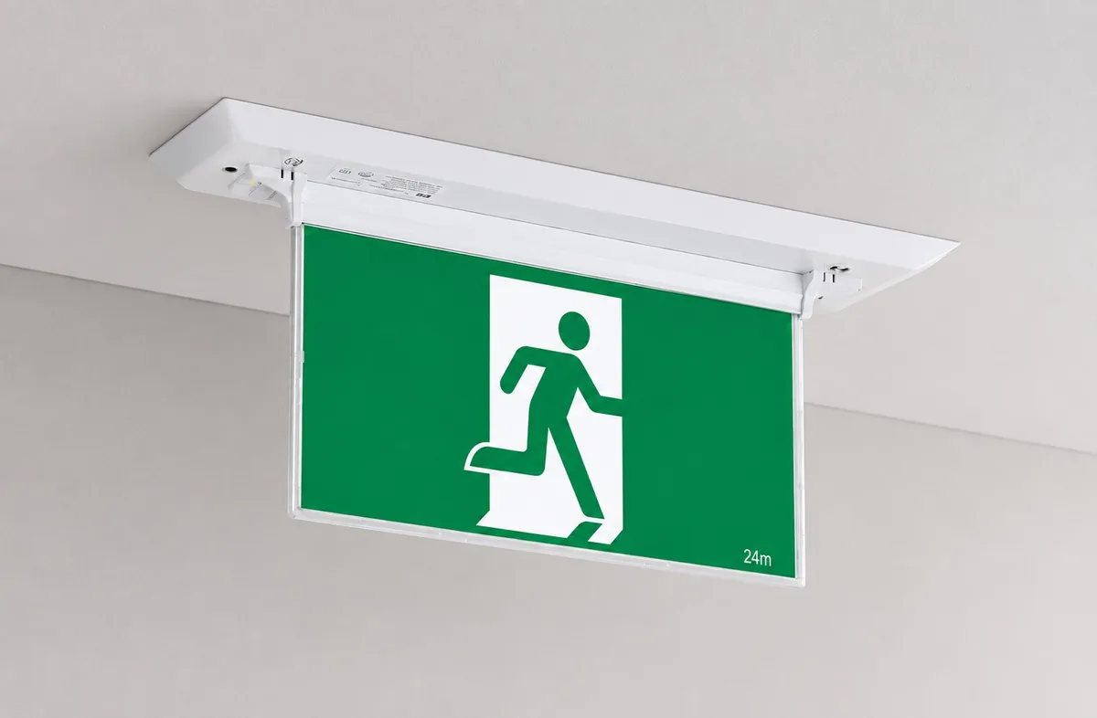 Recessed blade exit sign mounted in a commercial ceiling